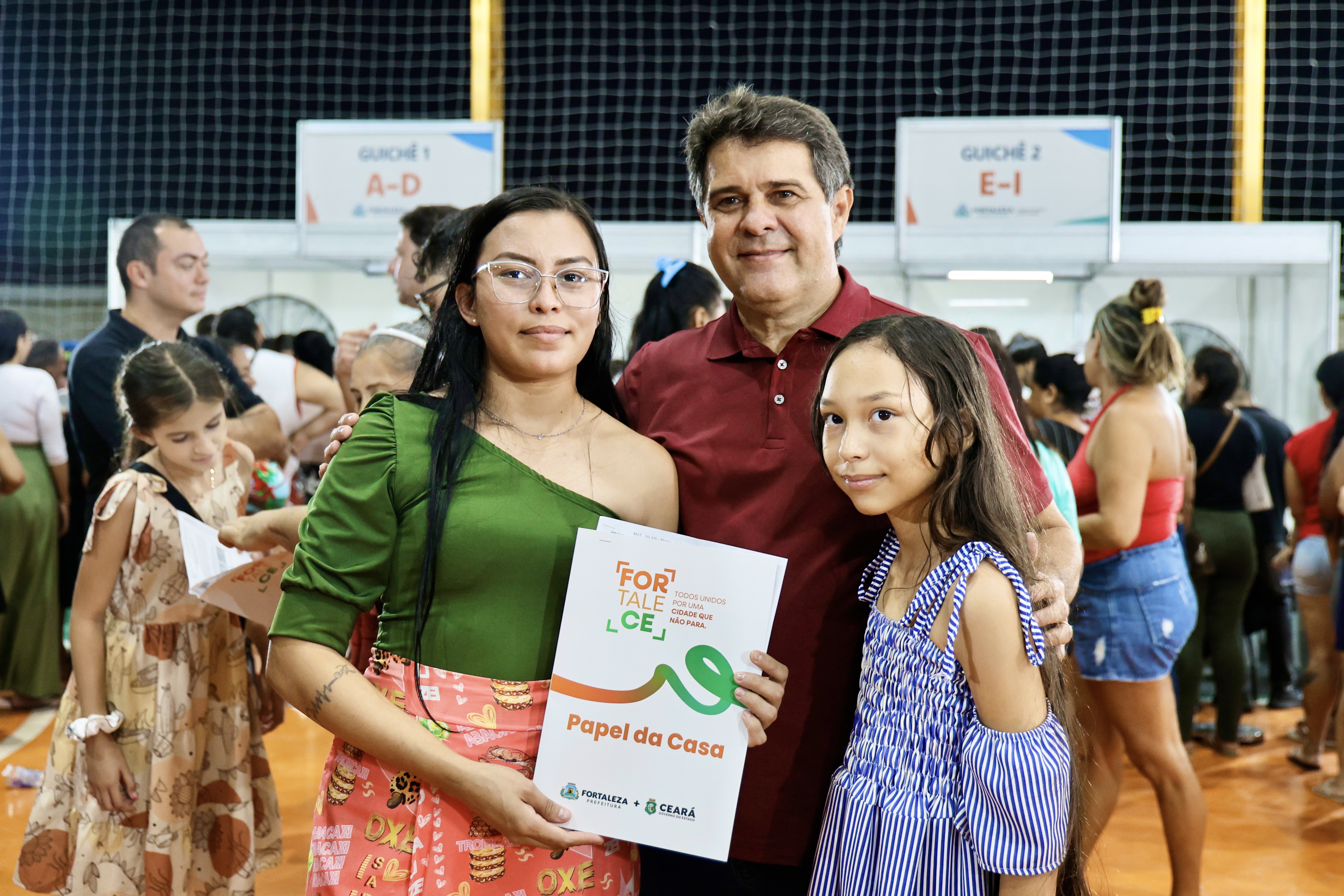 Prefeito Evandro posa ao lado de uma mulher e uma criança
